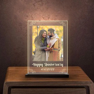 Personalized anniversary night lamp with color glow, displaying "Happy Anniversary 4/16/2022," placed on a wooden table with a warm, romantic ambiance