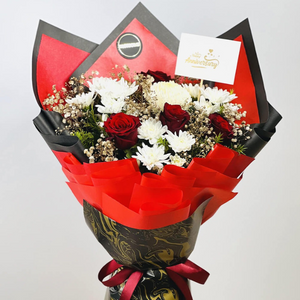 Red and white floral arrangement with baby’s breath and green fillers in luxury wrapping