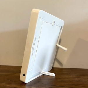 Back view of LED magic mirror photo frame with a white stand, displayed on a wooden surface