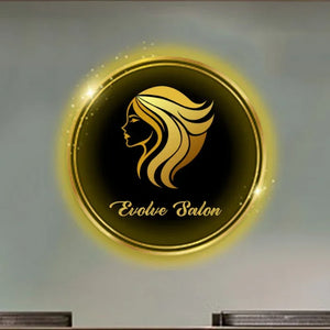 Custom beauty salon neon sign with "Evolve Salon" text and glowing silhouette, mounted on a wall above a wooden reception desk in a modern salon