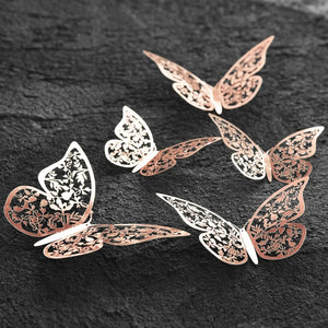Elegant butterfly wall decor in rose gold metal, 3D butterfly wall art with delicate floral cut design on dark textured background.