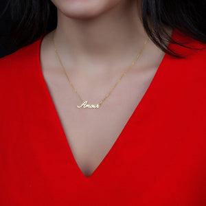 Customized name necklace in gold with the name "Amour," worn on a red top with dark hair visible