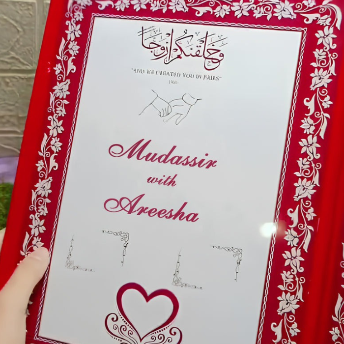 Open customized velvet Nikkah Nama certificate with "Mudassir & Areesha" text, featuring Islamic calligraphy and floral designs in a red velvet cover, held by a hand