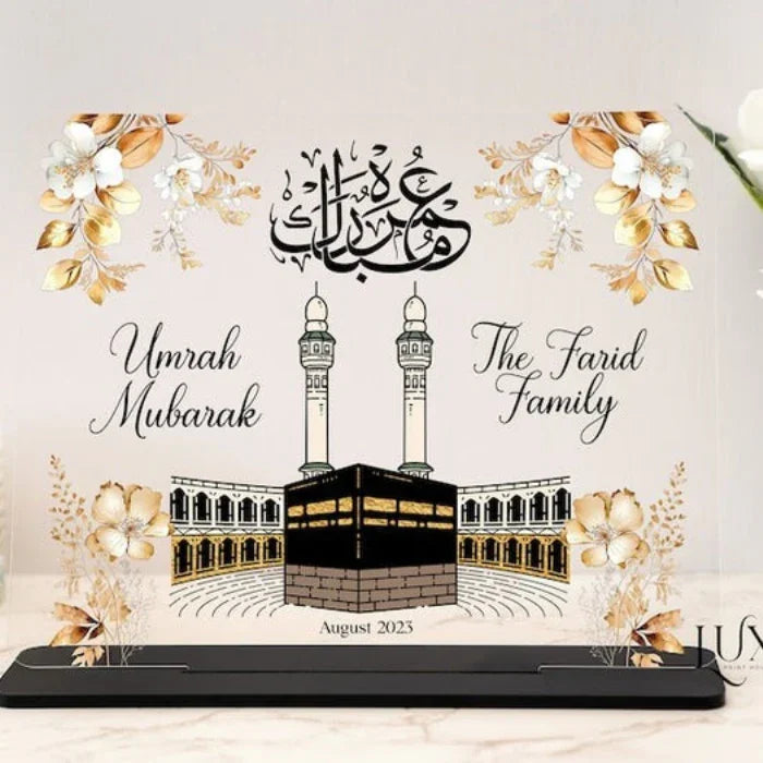 Custom Umrah Mubarak Acrylic Plaque featuring a beautiful Kaaba design, gold floral accents, and Arabic calligraphy, personalized with family names and date—perfect for Islamic gifts, Umrah return keepsakes, and special celebrations.