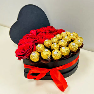 Heart-shaped gift box with red roses and Ferrero Rocher chocolates tied with a red ribbon.