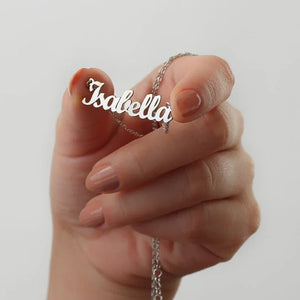 Personalized jewelry name necklace in silver with the name "Isabella," held in hand with a white background