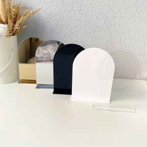 Set of four acrylic arch blanks in clear, white, black, and gold mirror finish with matching stands, ideal for DIY wedding signs and event decor.