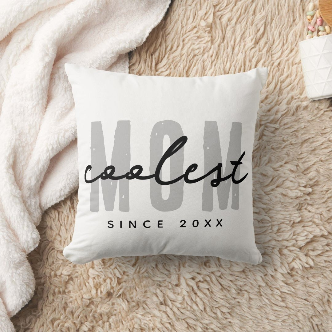 Coolest Mom Since 20XX Throw Pillow with customizable year on a fluffy rug