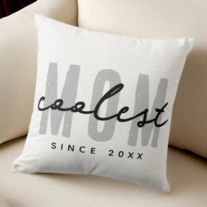 Coolest Mom Since 20XX Throw Pillow with customizable year on a cozy couch
