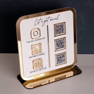 Freestanding acrylic business sign with QR codes for social media and Wi Fi access, placed on a modern reception counter.