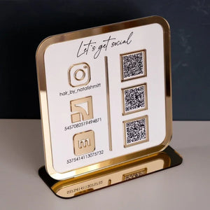 Freestanding acrylic business sign with QR codes for social media and Wi Fi access, placed on a modern reception counter.