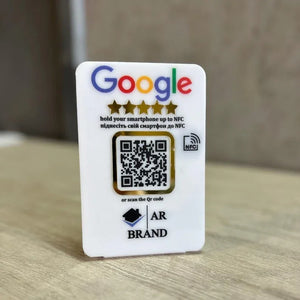 A sleek white acrylic Google Review NFC & QR Code Sign for businesses, featuring a scannable QR code and NFC tap functionality to leave instant reviews.