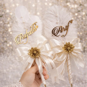 “Nikkah pen featuring elegant white feather design with personalized bride and groom names, luxury Islamic wedding signing pen with gold accents.