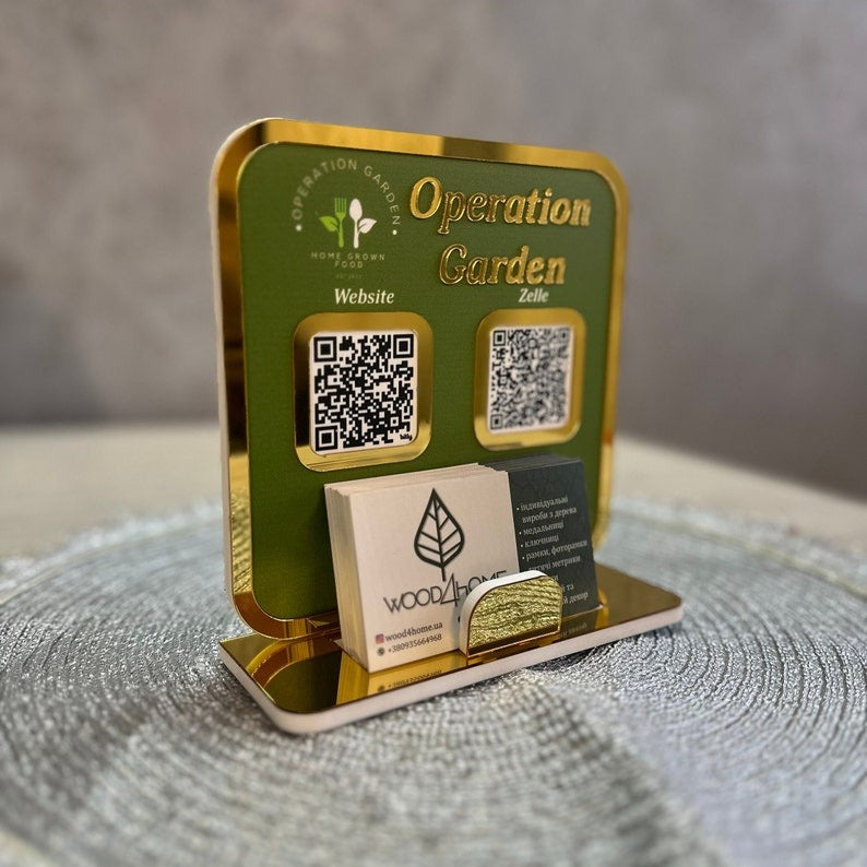 A green and gold Operation Garden QR Code Payment Sign with a business card holder, featuring QR codes for website access and digital payments via Zelle.