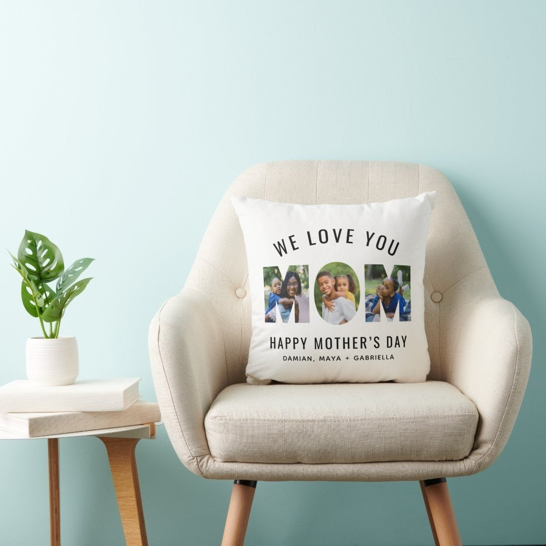 A personalized Mother’s Day throw pillow with a "We Love You Mom" 3-photo collage, placed on a beige chair with a plant and books