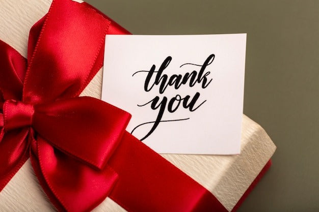 Thank you card with red ribbon on gift box, perfect for customized gifts and special occasions