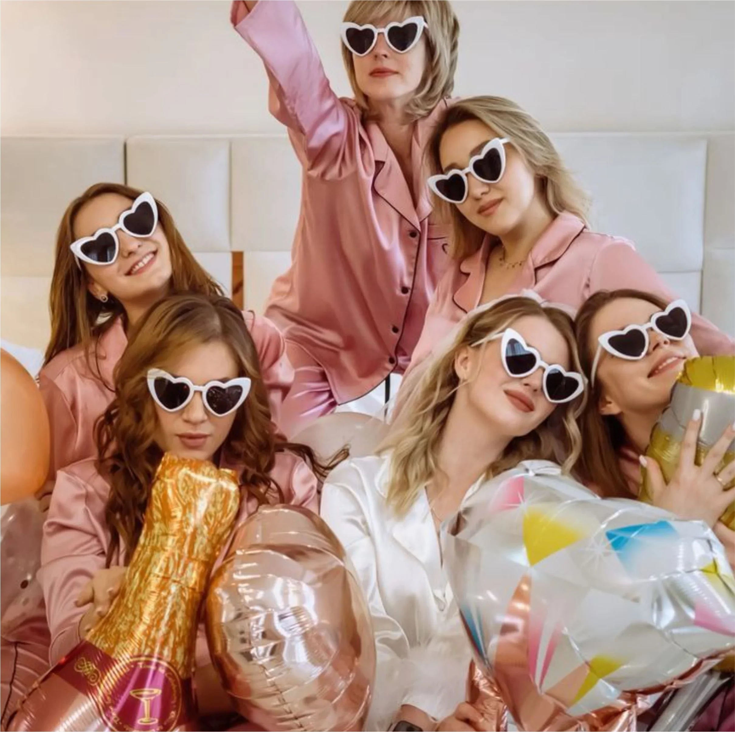 Women in pink pajamas with heart sunglasses and party balloons, perfect for birthday or bridal shower gifts