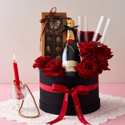 Luxury gift basket with red roses, champagne, chocolates, and candle – perfect for romantic occasions