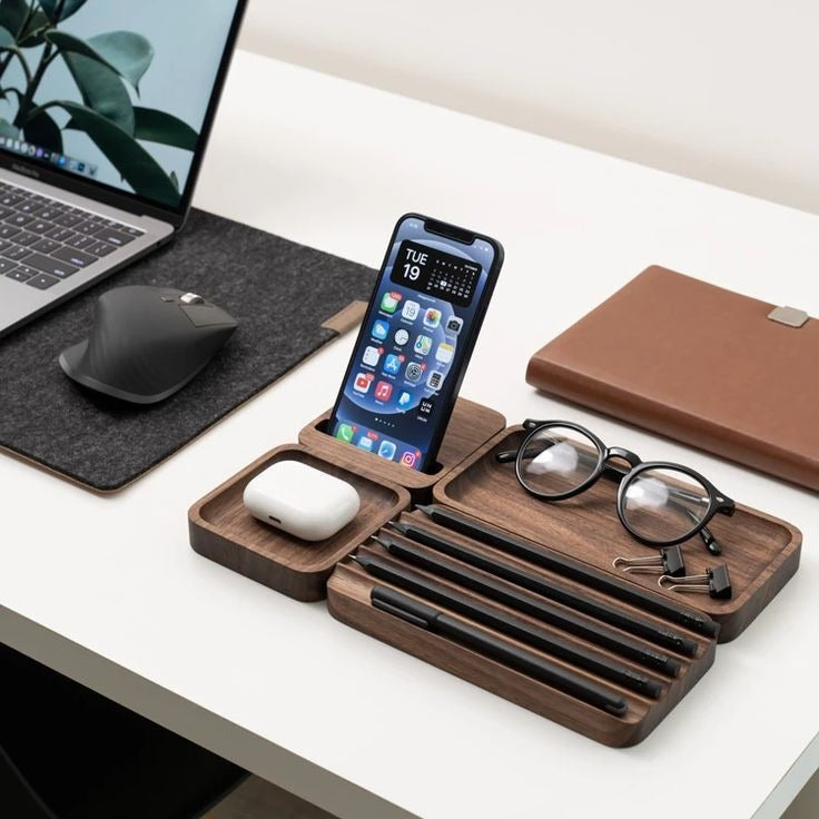 Stylish office desk setup featuring a wooden organizer for phone, pens, glasses, and accessories, alongside a laptop and card holder.