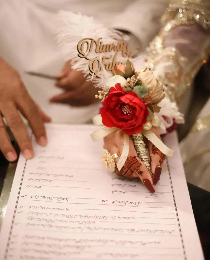 Nikah ceremony with henna hands, red rose corsage, and personalized name topper on document