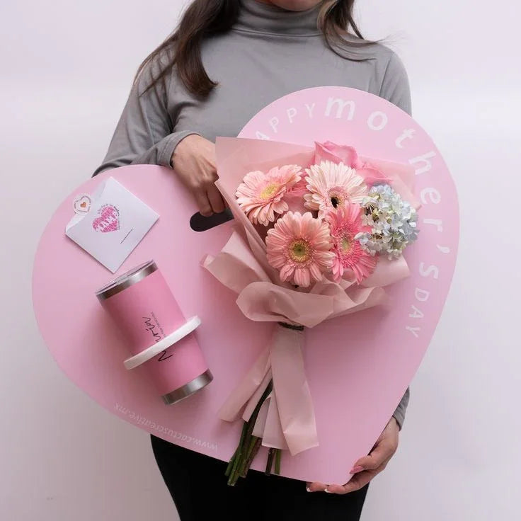 Happy Mother's Day gift set with pink gerbera bouquet, keepsake cup, and card in heart-shaped tray