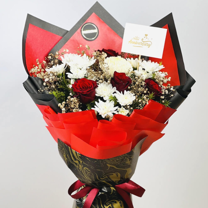 Red and white floral arrangement with baby’s breath and green fillers in luxury wrapping