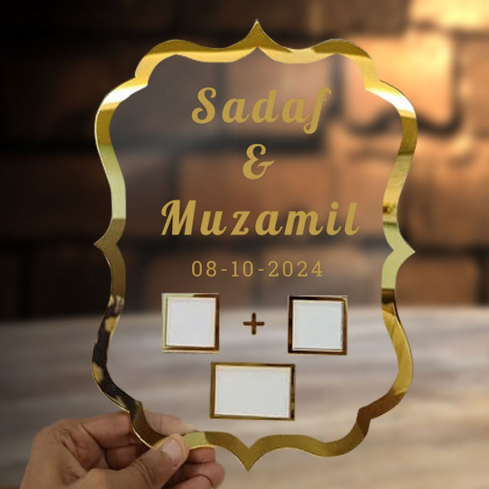 Personalized wedding thumb board with "Sadaf & Muzamil" and "08-10-2024," featuring gold borders and thumbprint spaces, held against a brick wall background