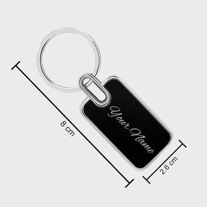 Black and silver keychain with custom name engraving, measuring 8 cm in length and 2.6 cm in width.