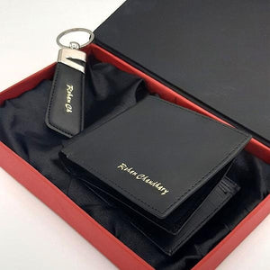 Customized black wallet with golden name engraving and matching keychain, displayed in a red gift box with black lining