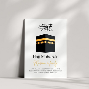 A modern Hajj Mubarak greeting card placed against a minimalist ceramic vase, featuring a Kaaba illustration and a Quranic blessing. A heartfelt Islamic gift for loved ones