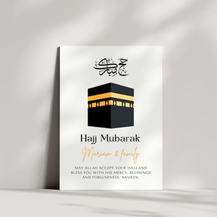 A modern Hajj Mubarak greeting card placed against a minimalist ceramic vase, featuring a Kaaba illustration and a Quranic blessing. A heartfelt Islamic gift for loved ones