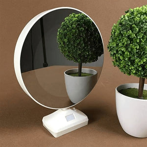 LED magic mirror photo frame in mirror mode, reflecting two potted plants, displayed on a brown textured surface