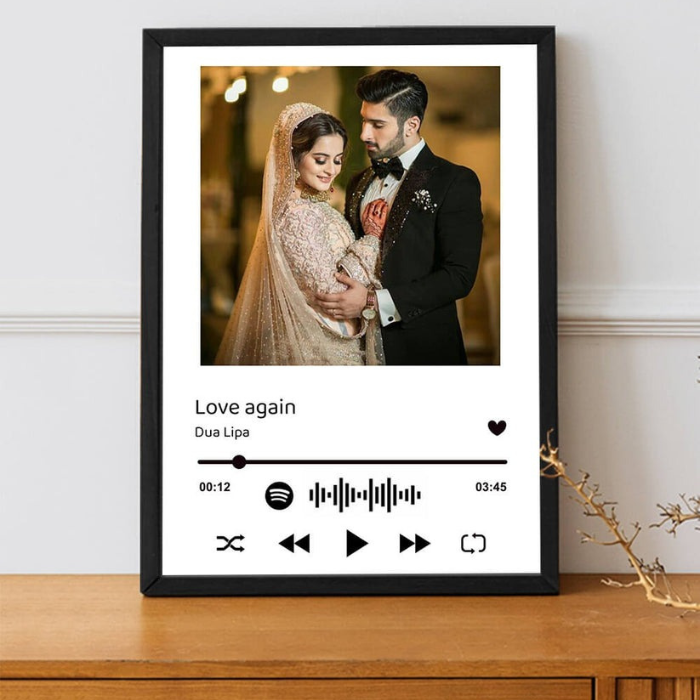 Customizable lyrical keepsake frame with a wedding photo and "Love Again" by Dua Lipa, featuring a Spotify waveform, displayed on a wooden surface