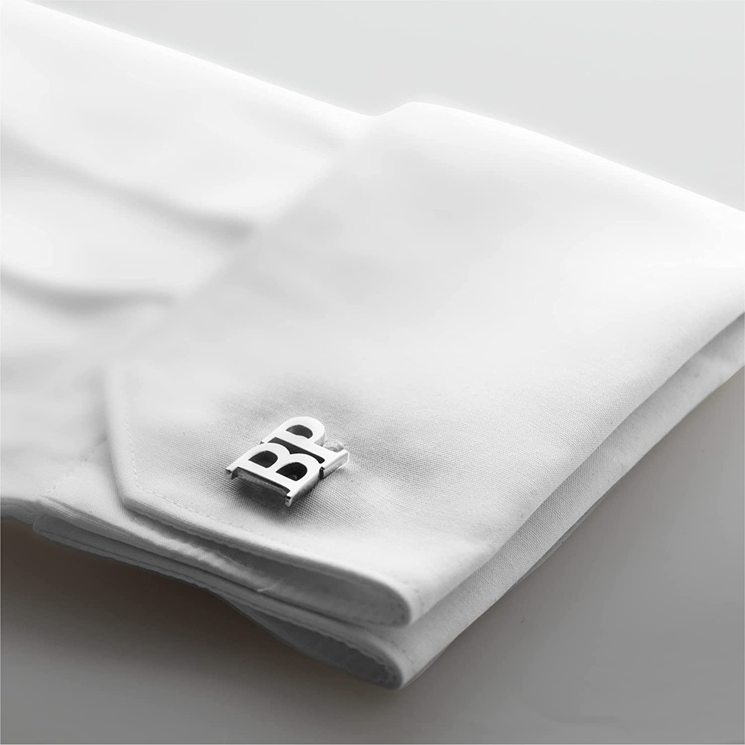 Personalized silver cufflinks with "BR" initials, displayed on a white shirt cuff with a navy blue suit