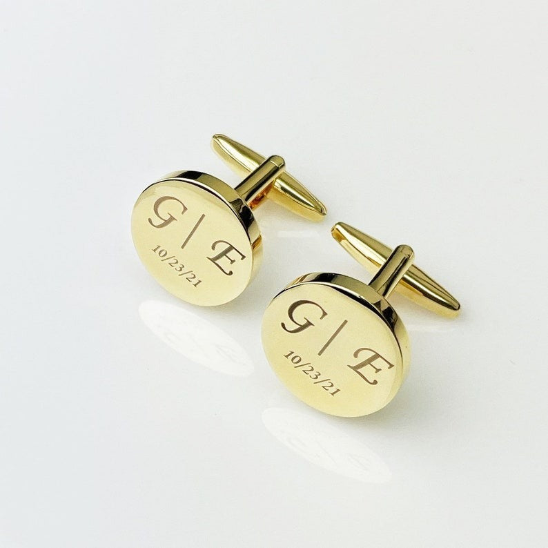Personalized gold cufflinks with "G E" initials and "10/23/21" date engraving, displayed on a white background