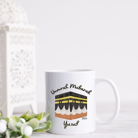  Personalized Umrah Mubarak mug with the Kaaba design and the name “Yusuf,” perfect for celebrating Umrah completion in 2023.