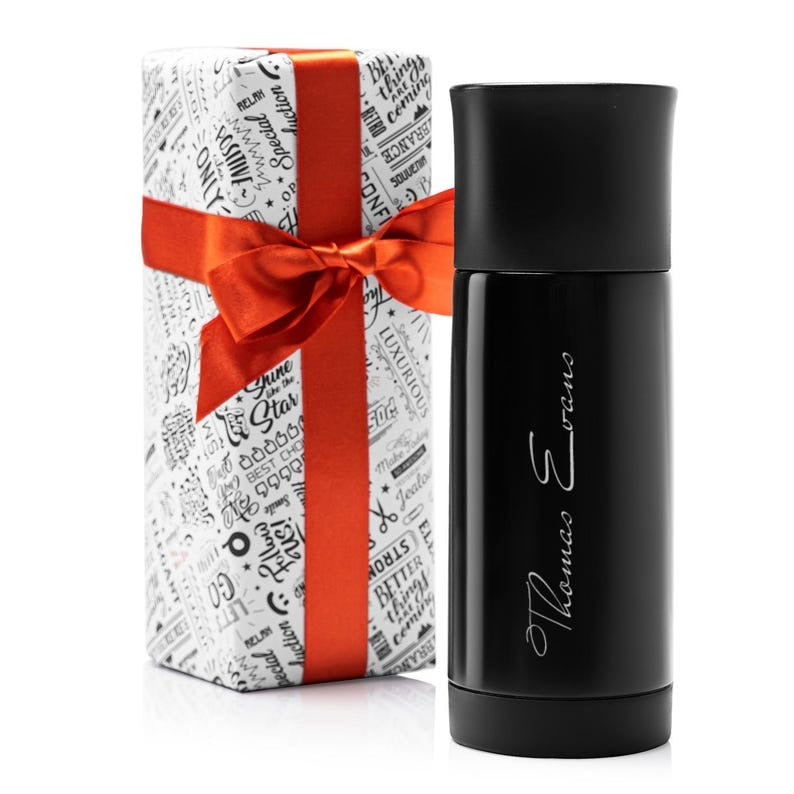 Personalized black stainless steel thermos with custom engraving, placed next to a gift box wrapped with a red ribbon.