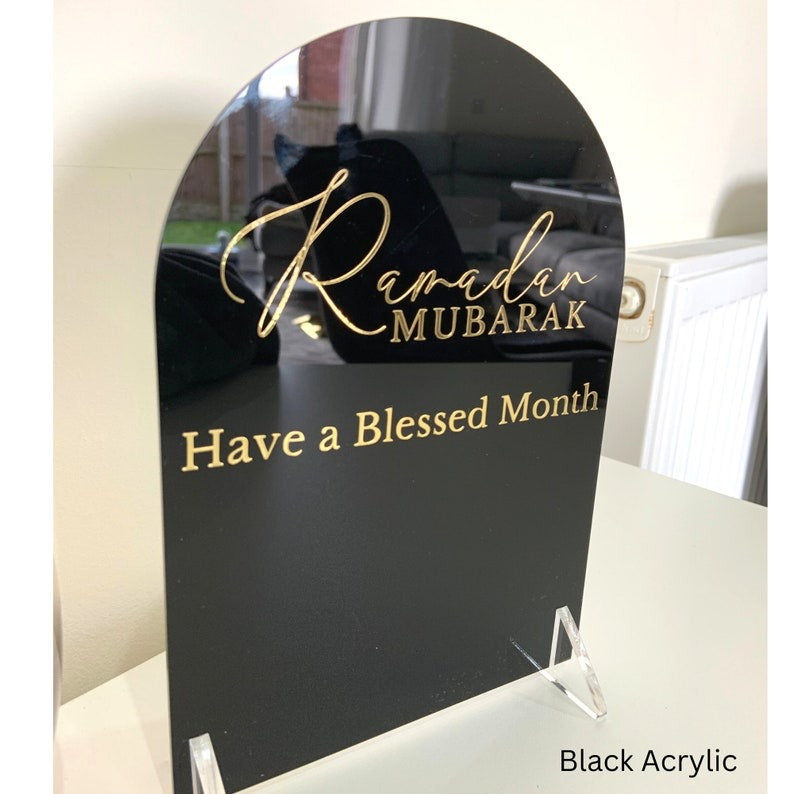 Ramadan Mubarak Acrylic Sign in black with gold Arabic calligraphy and the message "Have a Blessed Month.