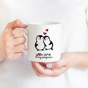 You Are My Penguin mug with romantic penguin design and hearts, held by hands