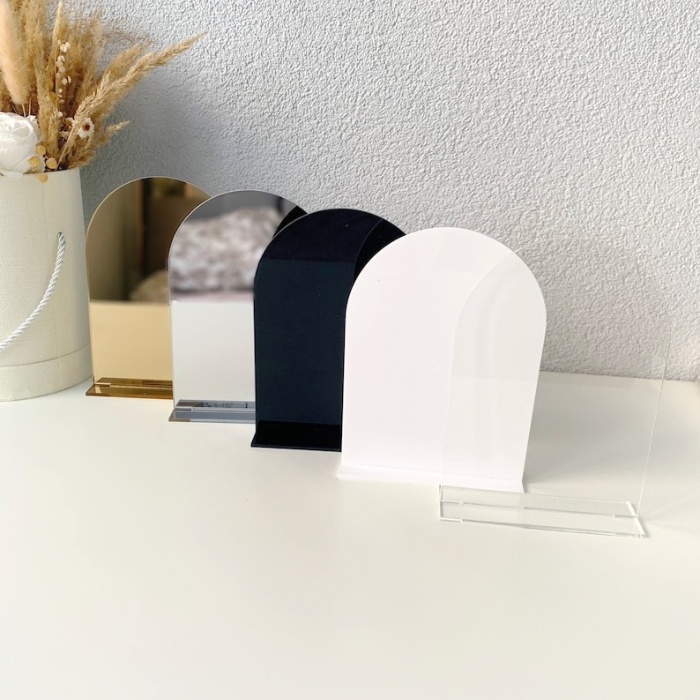 Set of four acrylic arch blanks in clear, white, black, and gold mirror finish with matching stands, ideal for DIY wedding signs and event decor.