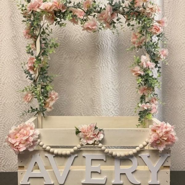  Baby Carrier Basket with "Avery" name, pink flowers, and greenery arch