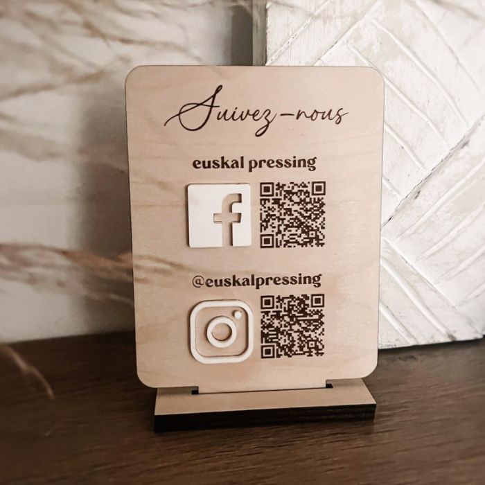 Custom wooden social media display stand featuring engraved text , the business name , QR codes for Facebook and Instagram, and their respective logos. Perfect for promoting online presence and encouraging social media engagement in a visually appealing way