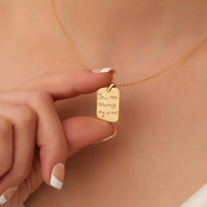 Elegant gold-plated handwriting necklace with a custom-engraved message, displayed on a soft white fabric background.
