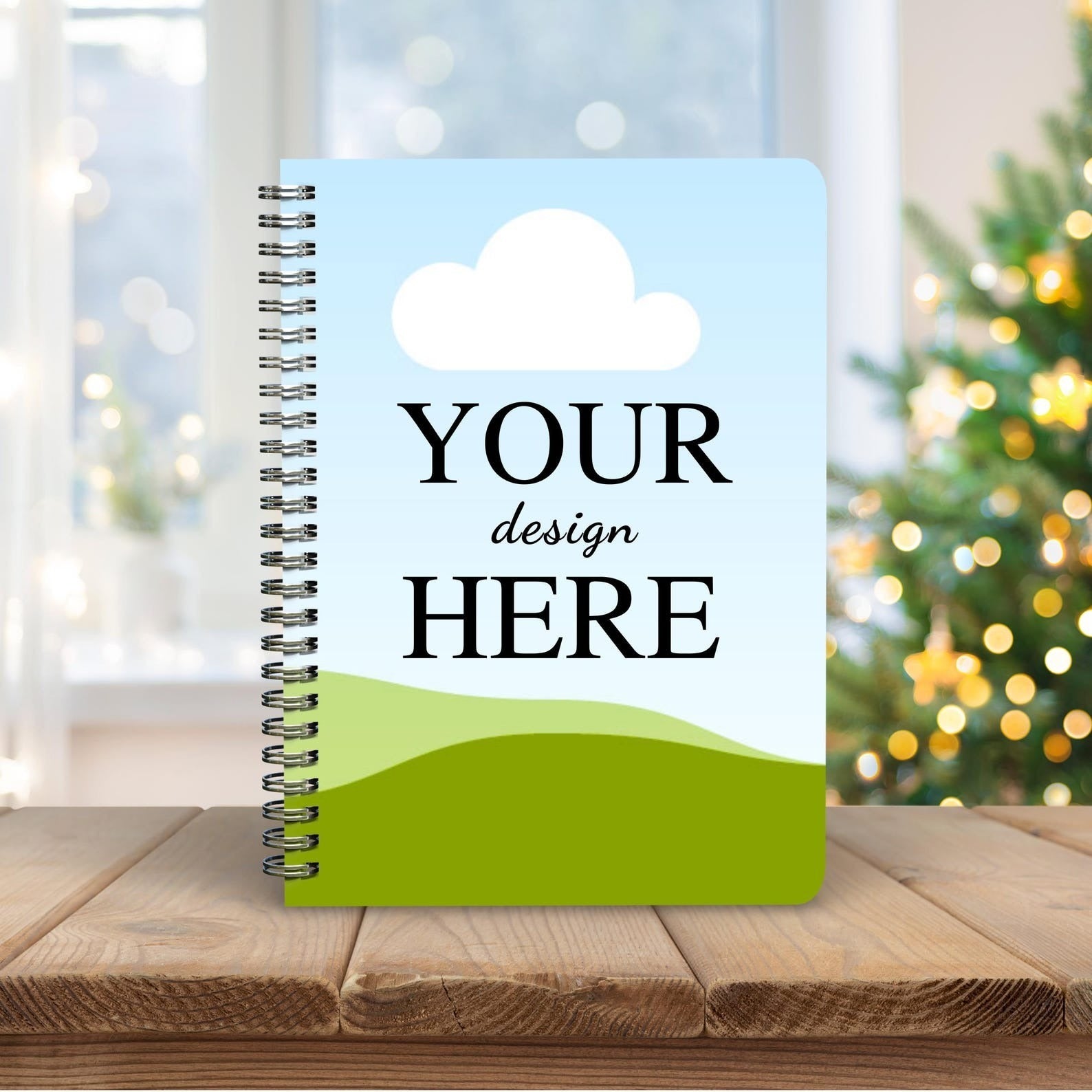 Customized ring-bound notebook with 'Your Design Here' displayed on the cover, styled on a wooden table with a festive background.
