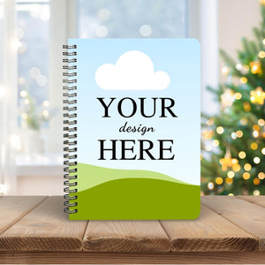 Customized ring-bound notebook with 'Your Design Here' displayed on the cover, styled on a wooden table with a festive background.