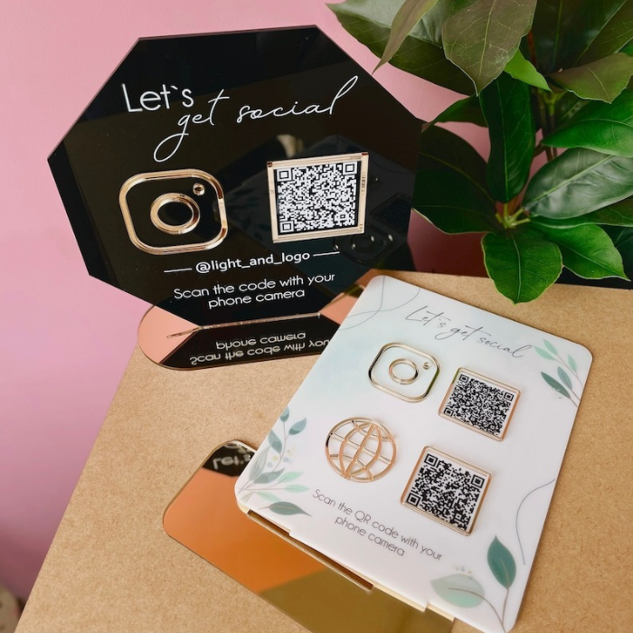  Set of two stylish acrylic QR code signs, one in black and one in floral design, featuring QR codes for social media links.