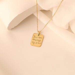 Personalized gold handwriting necklace worn on a woman's neck, featuring a custom-engraved heartfelt message.