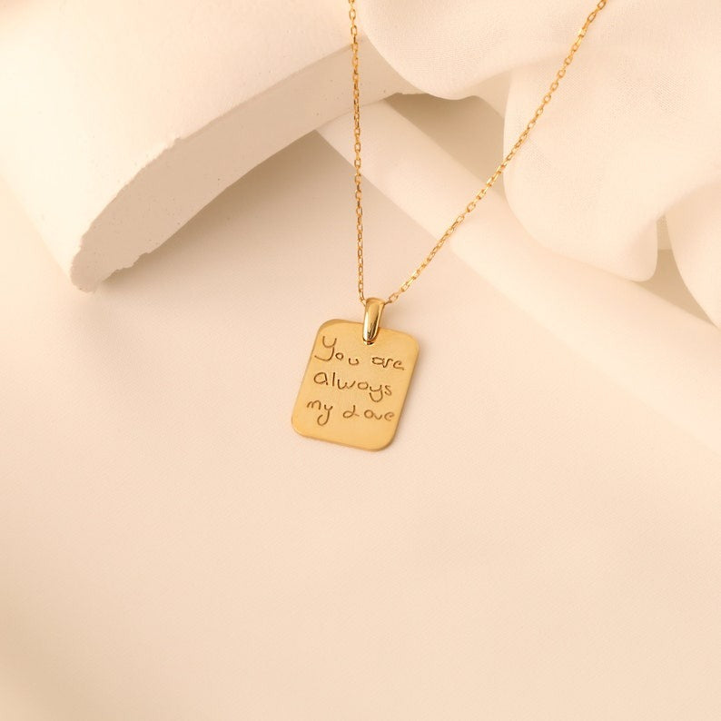 Personalized gold handwriting necklace worn on a woman's neck, featuring a custom-engraved heartfelt message.