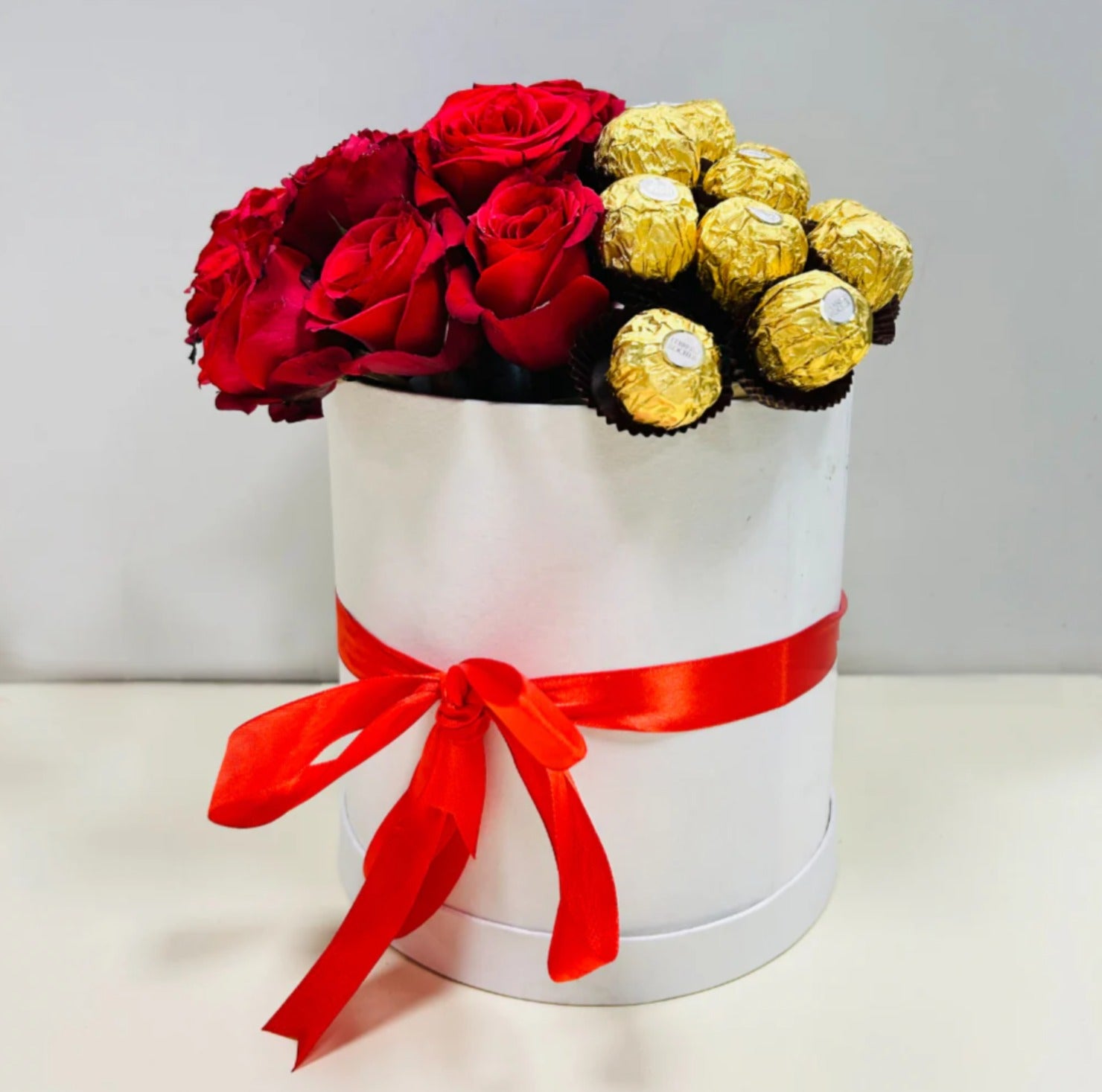 Elegant white gift box with red roses and Ferrero Rocher chocolates, adorned with a red satin ribbon—perfect for Valentine's Day, anniversaries, and luxury gifting