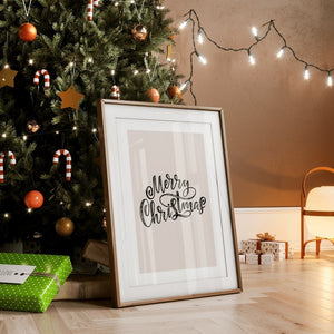 Elegant 'Merry Christmas' framed wall art placed beside a decorated Christmas tree with lights, creating a cozy holiday atmosphere